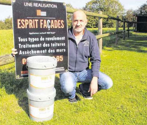 Homme agenouillé à côté de seaux et de panneau "Esprit FACADES"