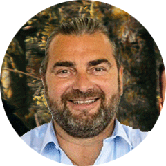 Homme souriant en chemise bleue.