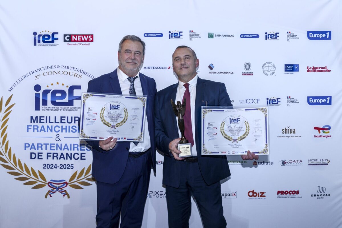 Deux hommes en costume tenant des trophées et des certificats.
