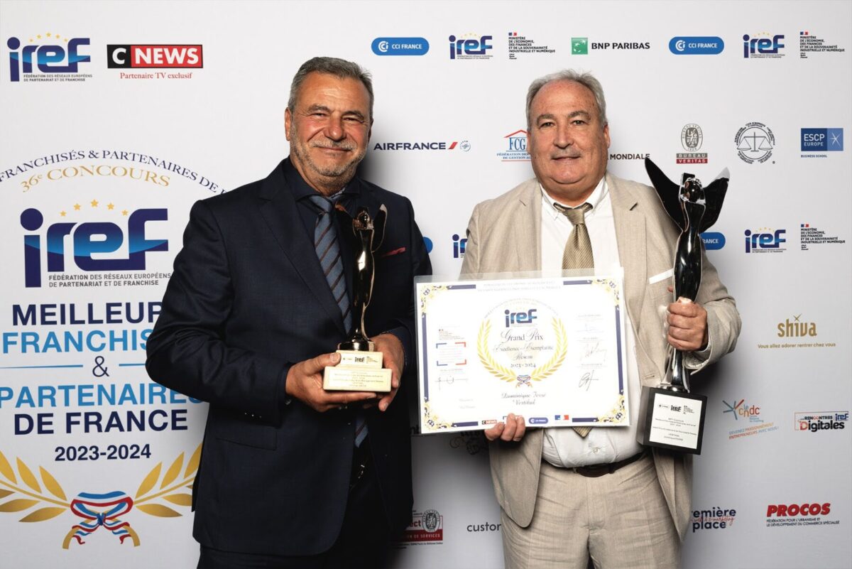 Deux hommes tenant des trophées et un certificat lors d'un événement IREF.